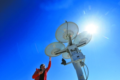 气象工作者顶着烈日在对设备进行检修.