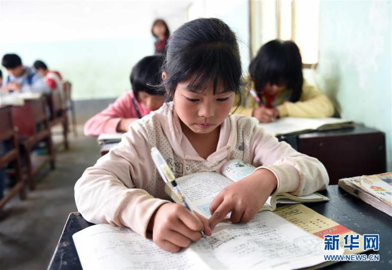 6月15日,宣威宝山镇留守儿童之家的孩子在"家里"做课外作业.